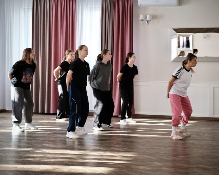 Zajęcia taneczne na sali: uczestnicy Dance Camp ćwiczą pod okiem instruktorki